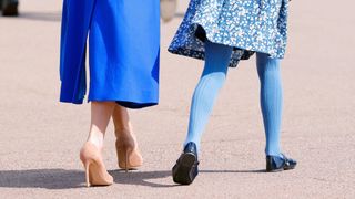 rear shot of Kate Middleton wearing stilettos walking next to daughter Princess Charlotte