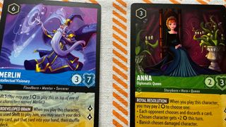 Two Disney Lorcana cards on a white and orange background