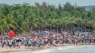 An excited crowd watches the lift-off of China’s Long March 5B rocket with the core module of the Tianhe space station aboard.