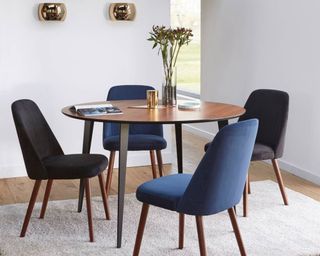 La Redoute Watford Round Vintage-Style Dining Table inside room with velvet chairs atop white rug