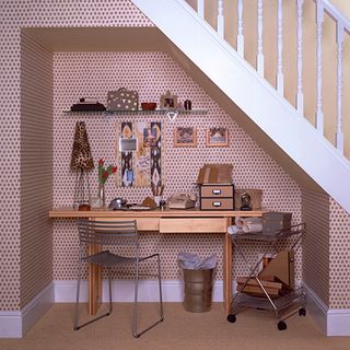 home office under stairs with wooden desk and chair
