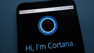 a phone with the words "Hi I'm Cortana" on the screen