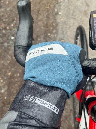 A rider wearing Madison DTE winter gloves holding the handlebars in the rain