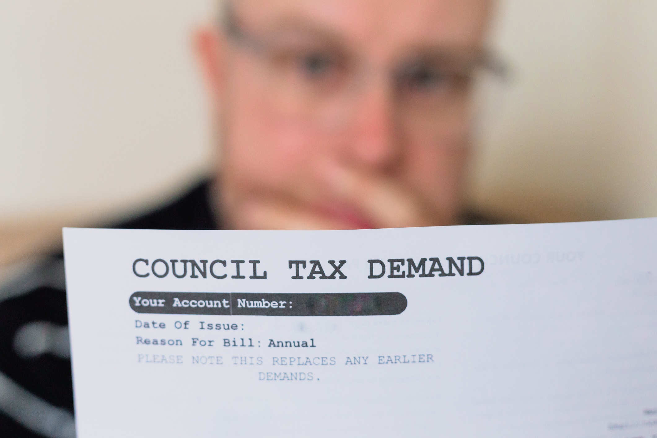 Council tax bill in the hands of a worried man