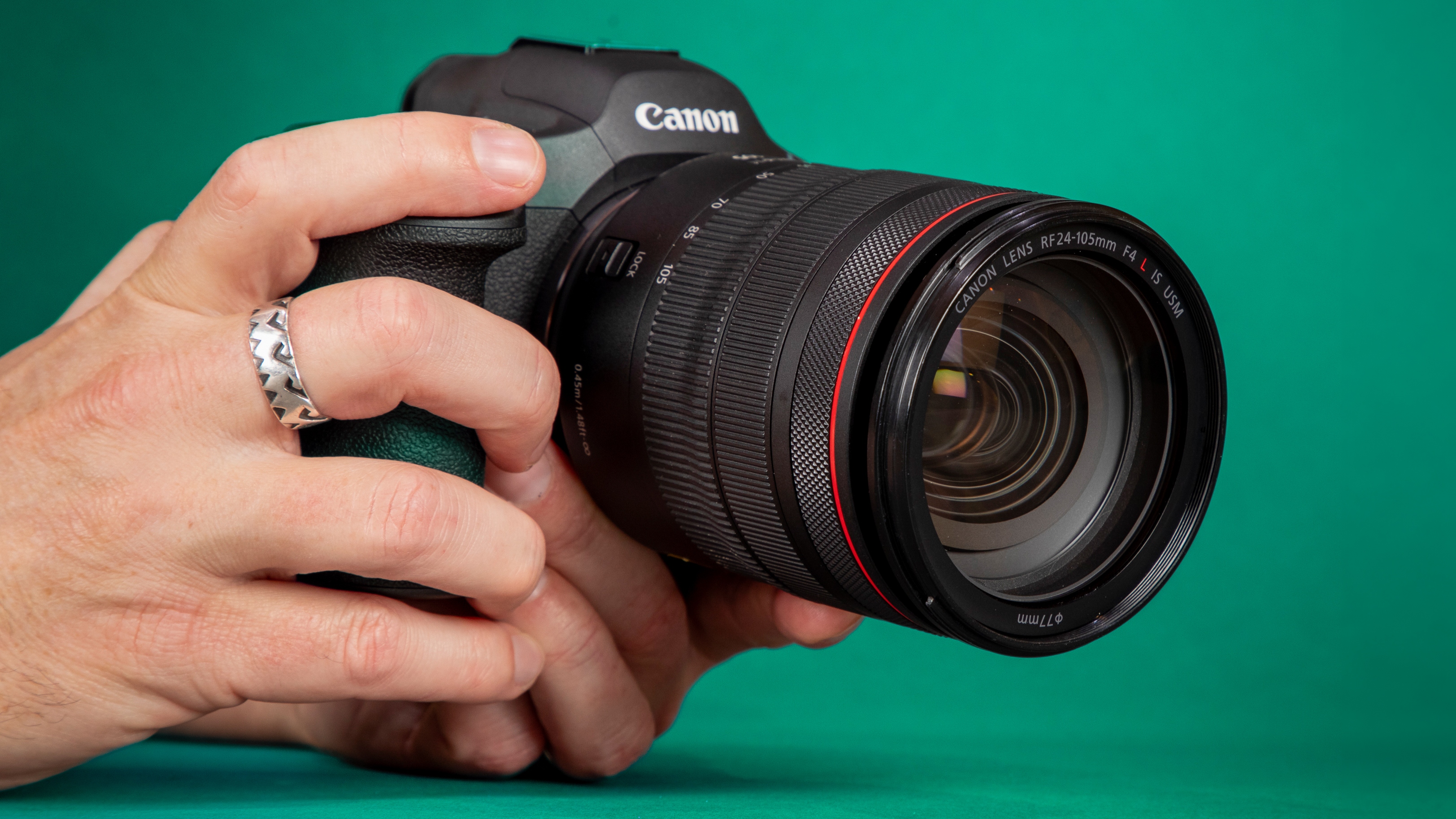 Canon EOS R5 Mark II in person's hands against a green backdrop