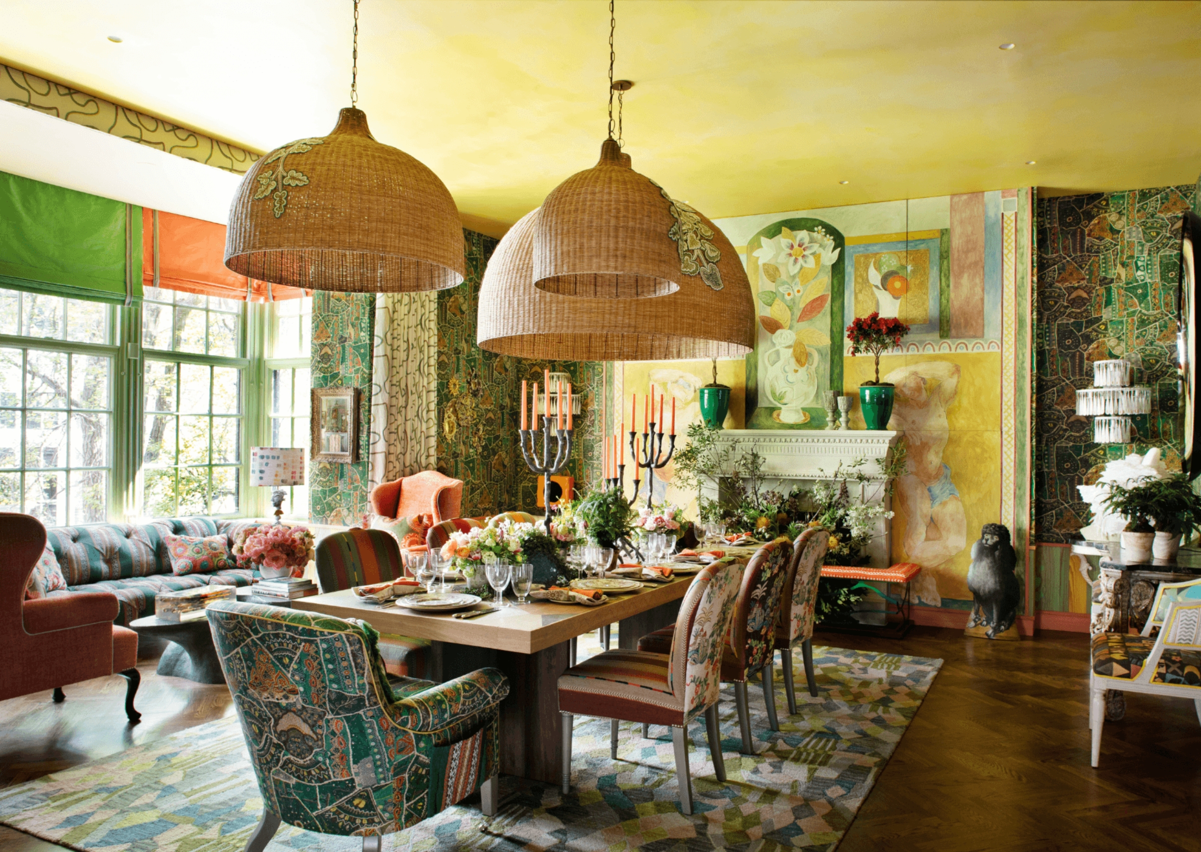 a dining room with a yellow ceiling and filled with pattern, color, and oversized pendant lighting