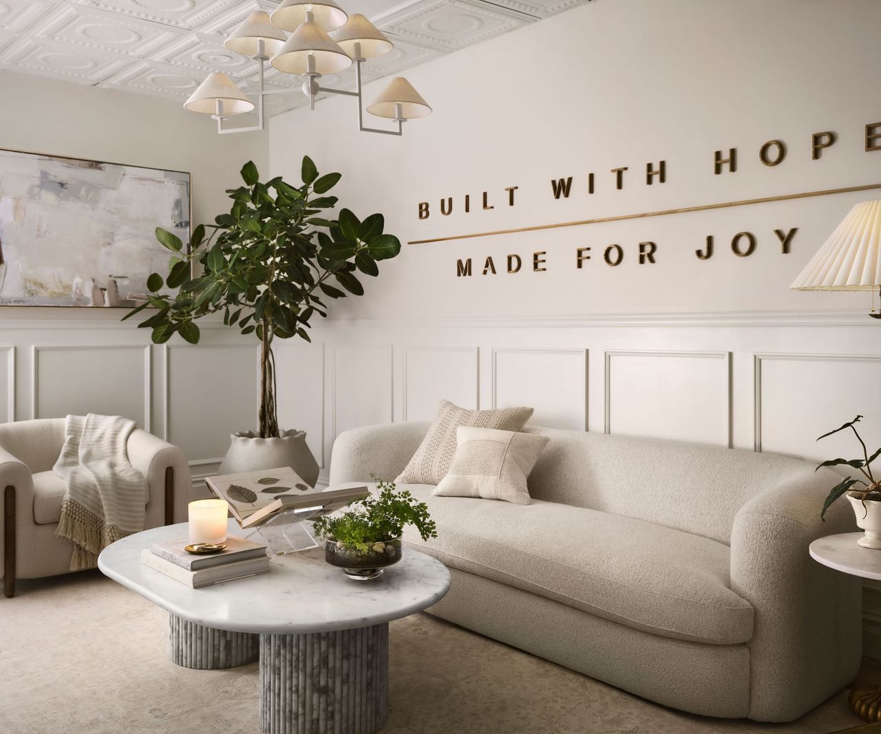 Office with molding, cream sofa, marble coffee table and pendant