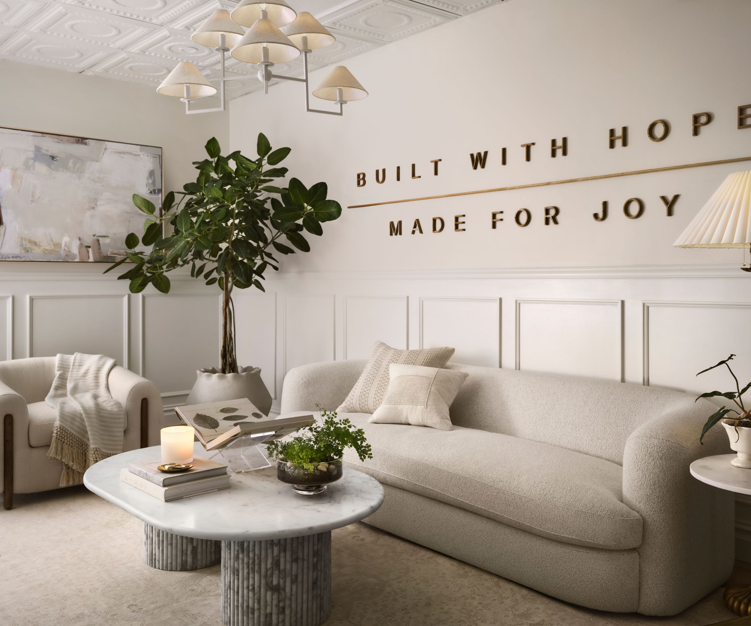 Office with molding, cream sofa, marble coffee table and pendant