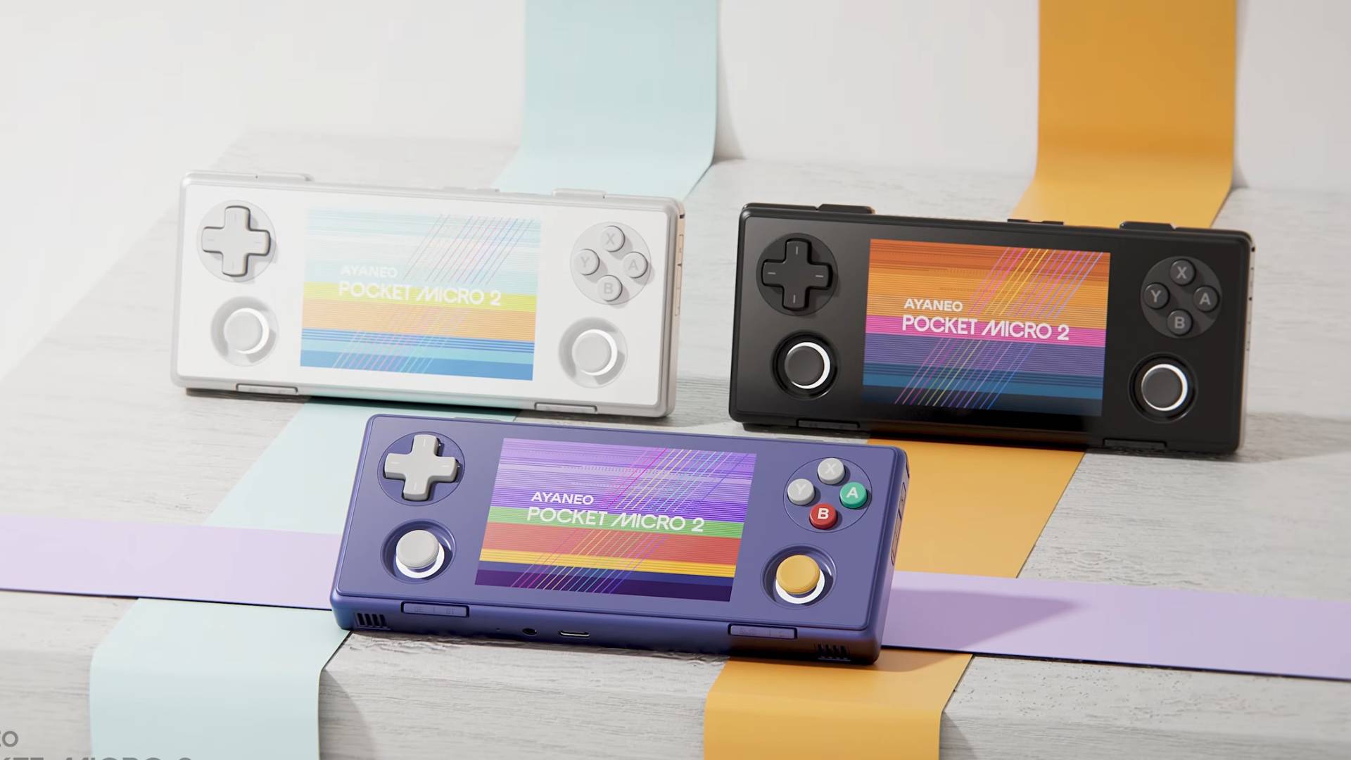 Three Ayaneo Pocket Micro 2 handheld with Frosty White on top left, Midnight Black on top right, and Stardust Purple at centre bottom.