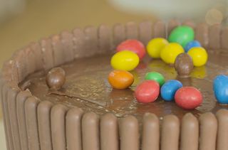 Scattering sweets onto a chocolate cake