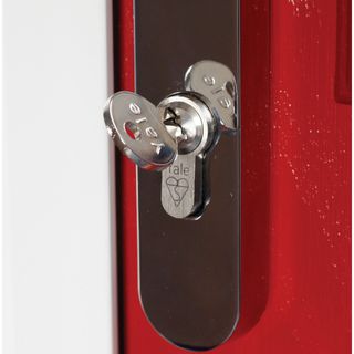 Silver key in lock on red door