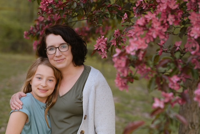 A mom with her child under a blossoming cherry tree
