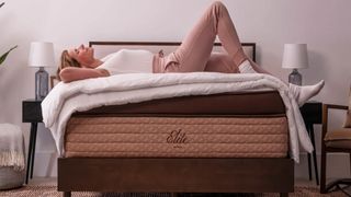 Helix mattress sales and deals image shows a woman with blonde hair relaxing on top of the Helix Dusk Elite Mattress 