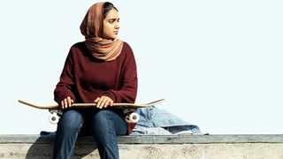 Geraldine Viswanathan as Hala Masood holding a skateboard during one of the best Apple TV movies, Hala.