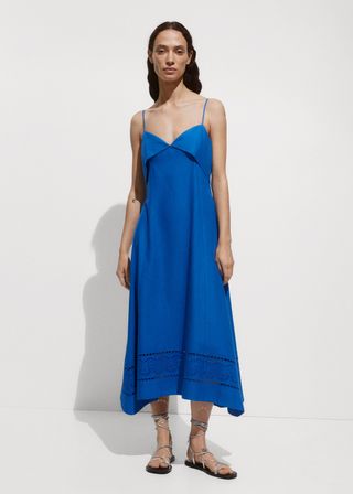 A model wears a blue midi dress with embroidered elements by mango