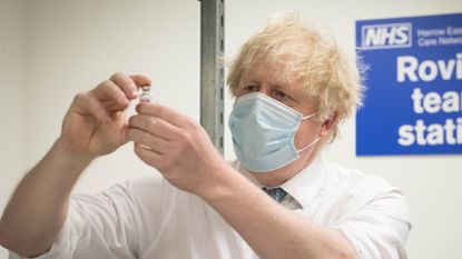 Boris Johnson holds a vial of the Oxford-Astrazeneca Covid vaccine
