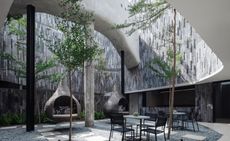 A image of the hotels pebbled courtyards sprinkled with water hammocks and sofa pods