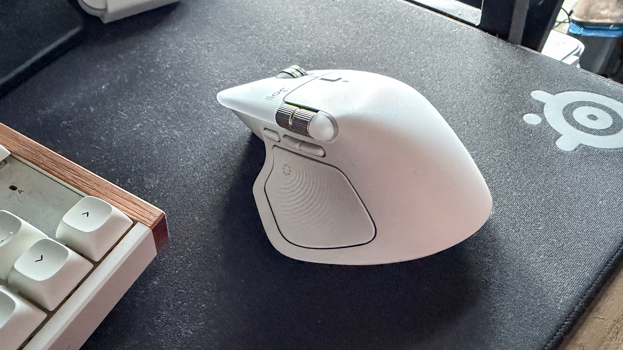 Logitech MX Master 4 mouse on mouse pad next to keyboard