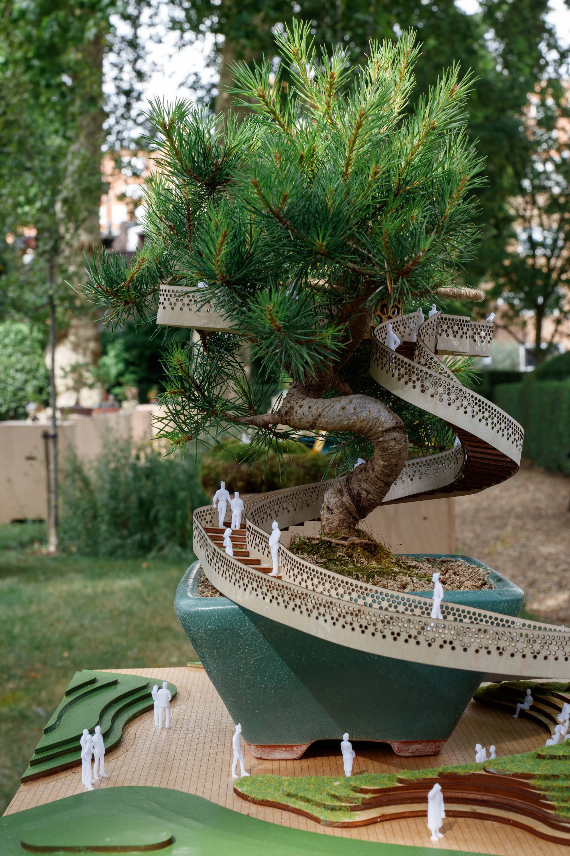 view of miniature houses in a park as part of an open air Bonsai treehouse exhibition in London