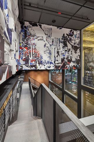 Interior view of the upper level at the Hyundai Music Library featuring a wall filled with painted electrical items. There is another wall with colourful wall art made up of a face and other elements