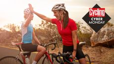 Two female cyclists high five, with Cyber Monday logo