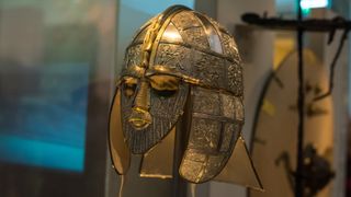 A close-up of the Sutton Hoo helmet on display in a museum