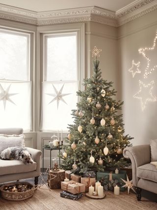 neutral Christmas living room with neutral decorations, two sofas, coir rug, hanging stars