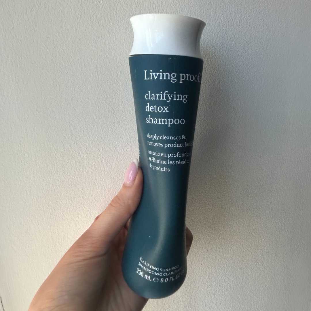 Hand holding empty bottle of Living Proof Clarifying Detox Shampoo