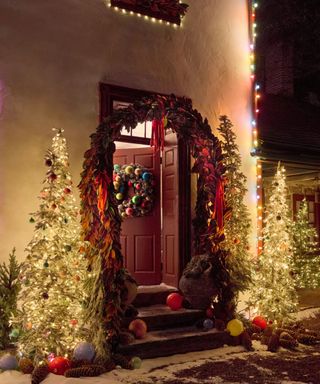 Decorated Christmas porch with tree and garland around the door