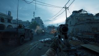 Moving through a wartorn street near a tactical vehicle in Delta Force: Black Hawk Down with your gun out, the light is dark