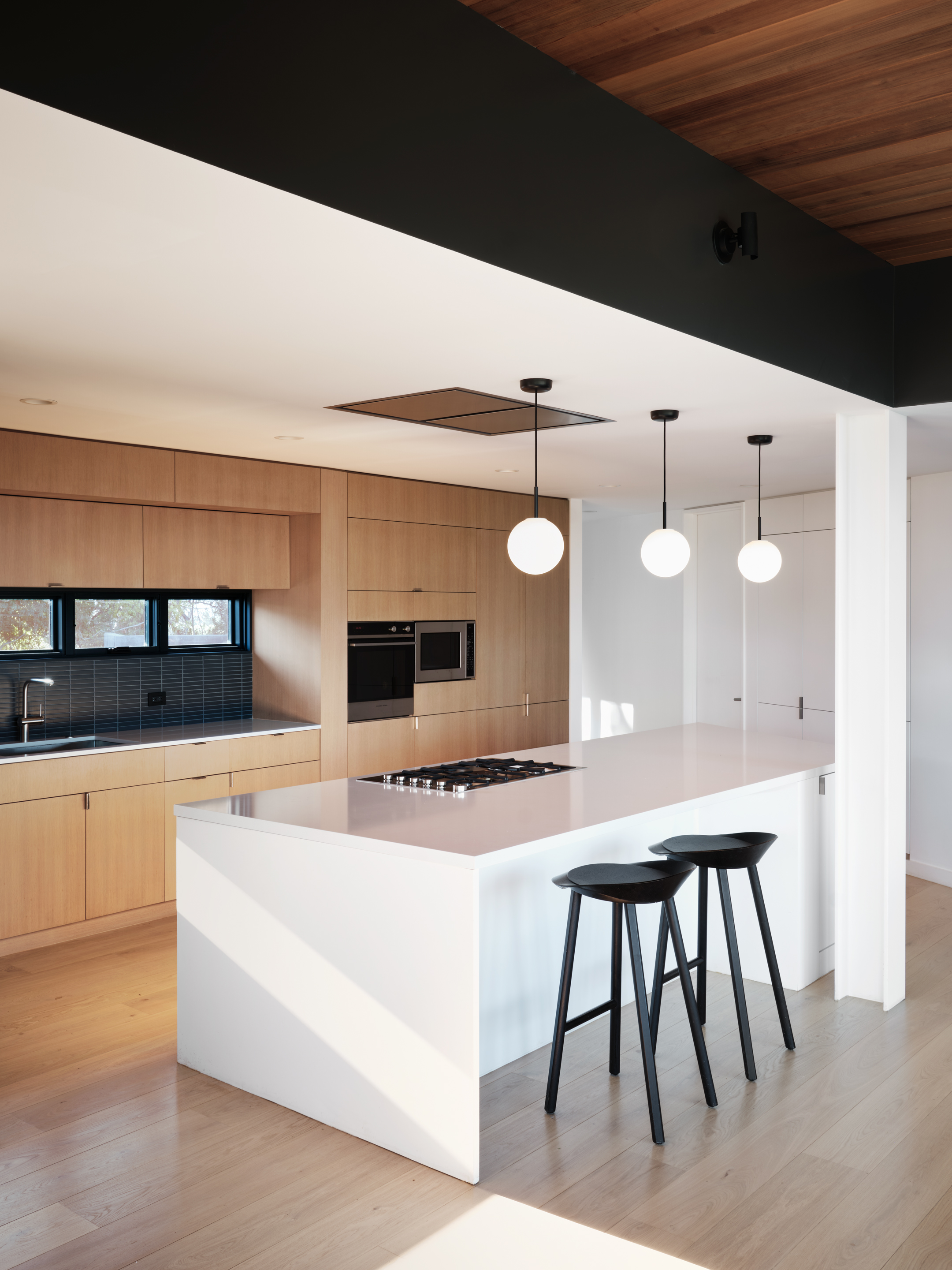 Hilltop Residence by Michael Hennessey Architecture, a modernist inspired home, low lying and linear with timber ceilings and black accents