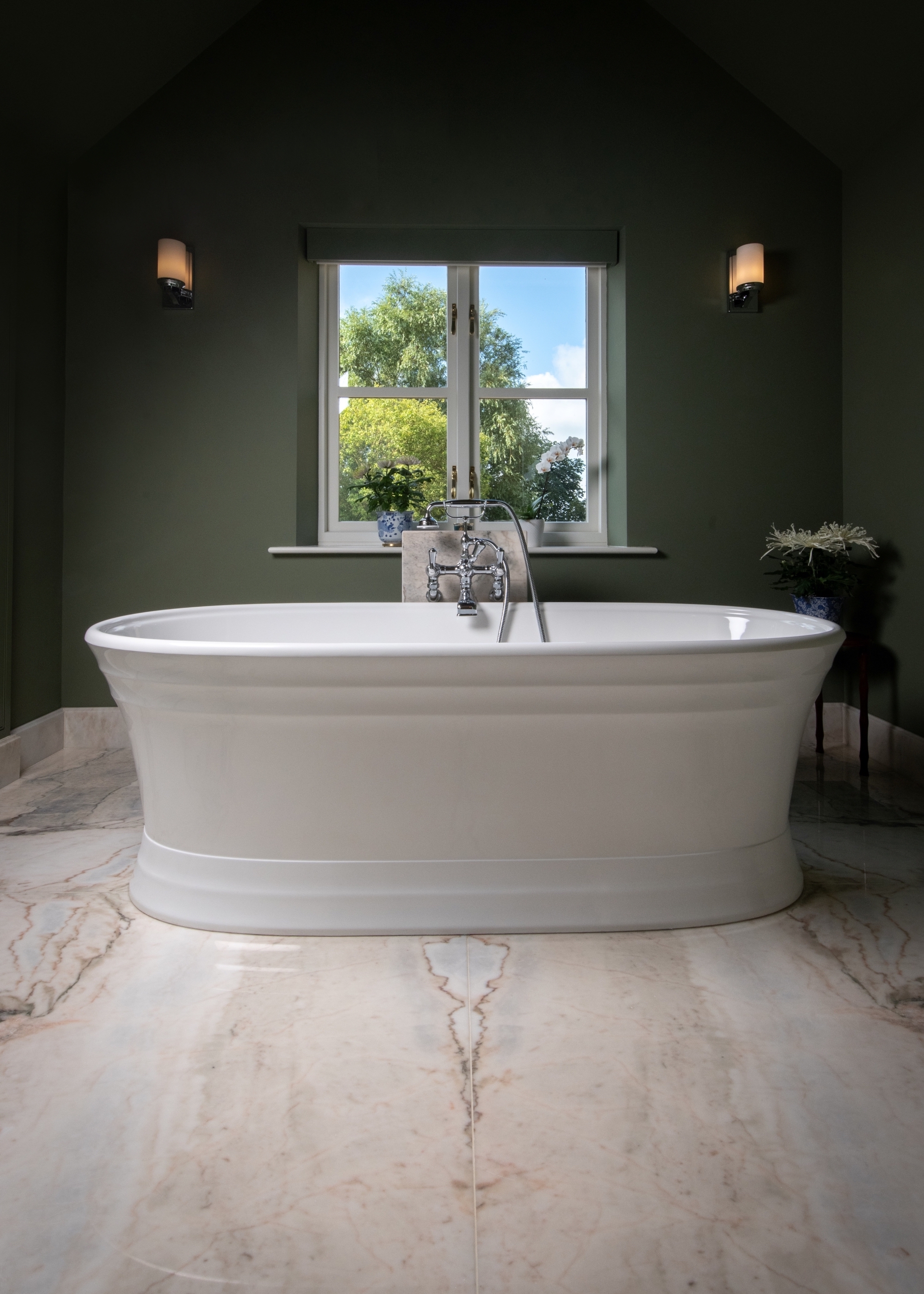 bathroom with white freestanding bath and bookmatched marble flooring and a window with a view