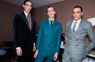 3 male models in dress suits looking towards the camera