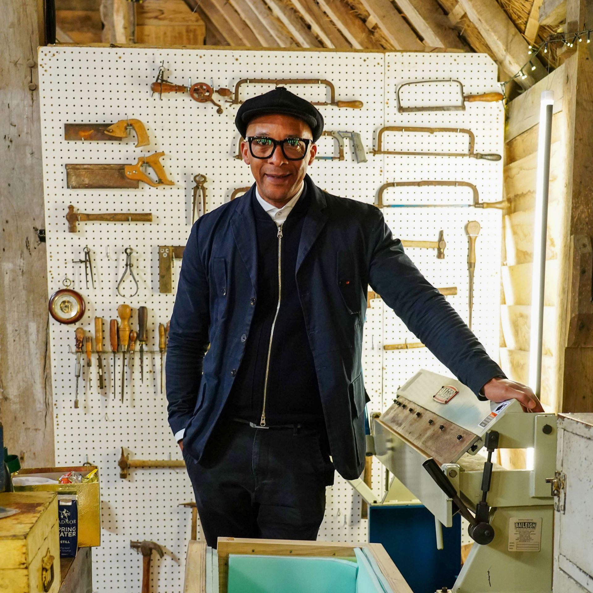 Jay Blades standing in front of a wall of tools