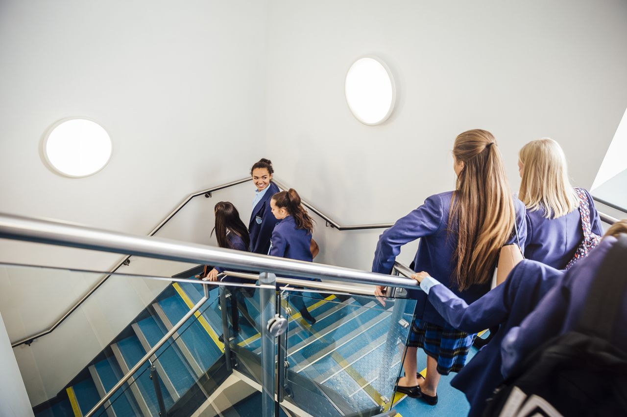 School children in uniform walking downstairs