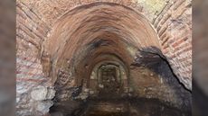  Here we see an underground chamber with brick-lined walls.