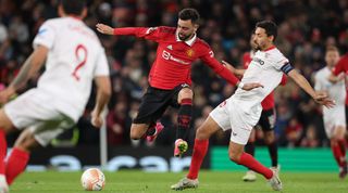 Bruno Fernandes of Manchester United evades a tackle by Jesus Navas of Sevilla during the UEFA Europa League quarter-final first leg match between Manchester United and Sevilla at Old Trafford on April 13, 2023 in Manchester, United Kingdom.