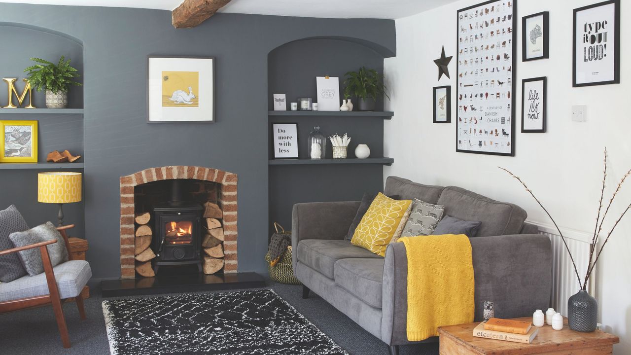 Grey and white living room with alcove storage, grey sofa and yellow accents from a throw, cushion, lamp and artwork