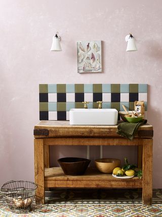 A bathroom sink with a colourful tile backsplash