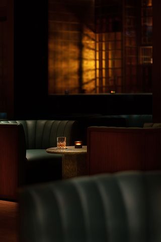 view of a dimly lit restaurant, blue leather booths and light from lamp