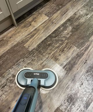 Shark Scrub & Steam mop in use on grey vinyl tile kitchen flooring