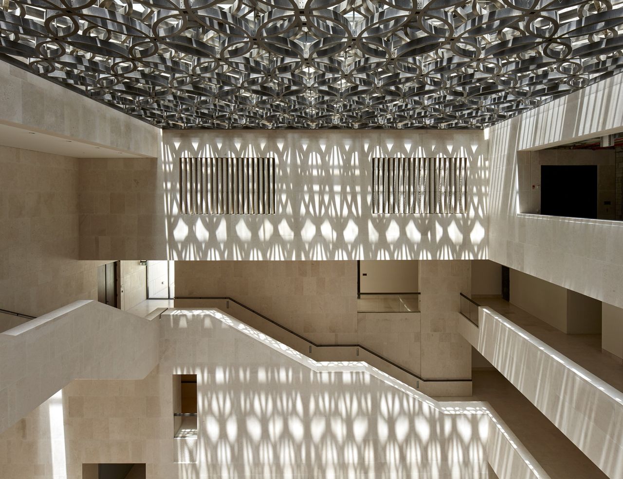 Interior with light filtering through the roof and the design reflectinf on the walls and stairs