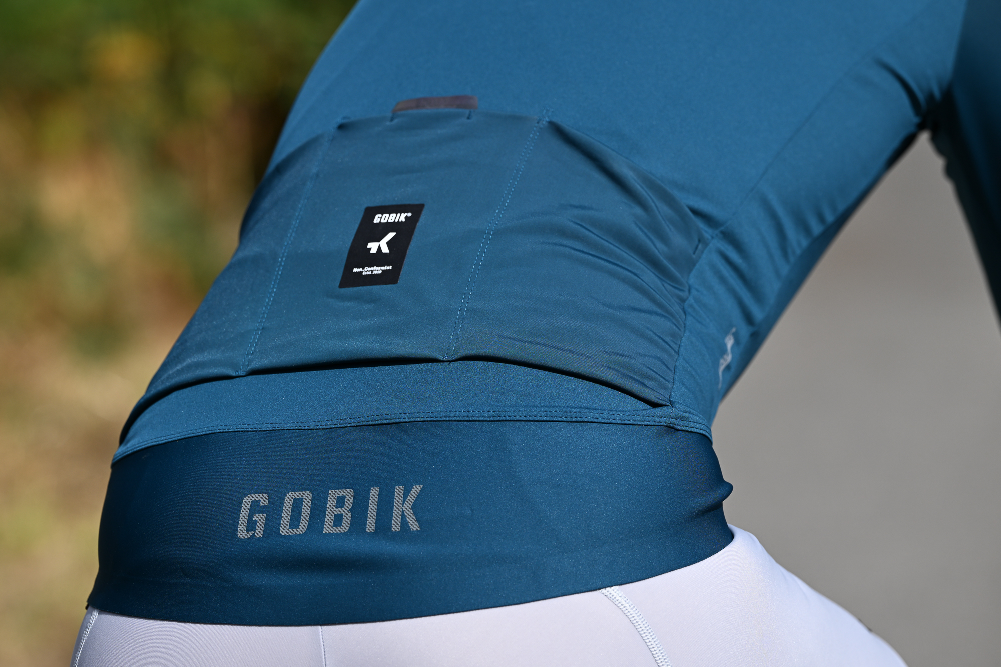 rear view of a man wearing a green jersey showing the three rear pockets and long rear flap