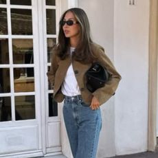 Influencer @fakerstrom wears a cropped jacket with blue jeans and black flats.