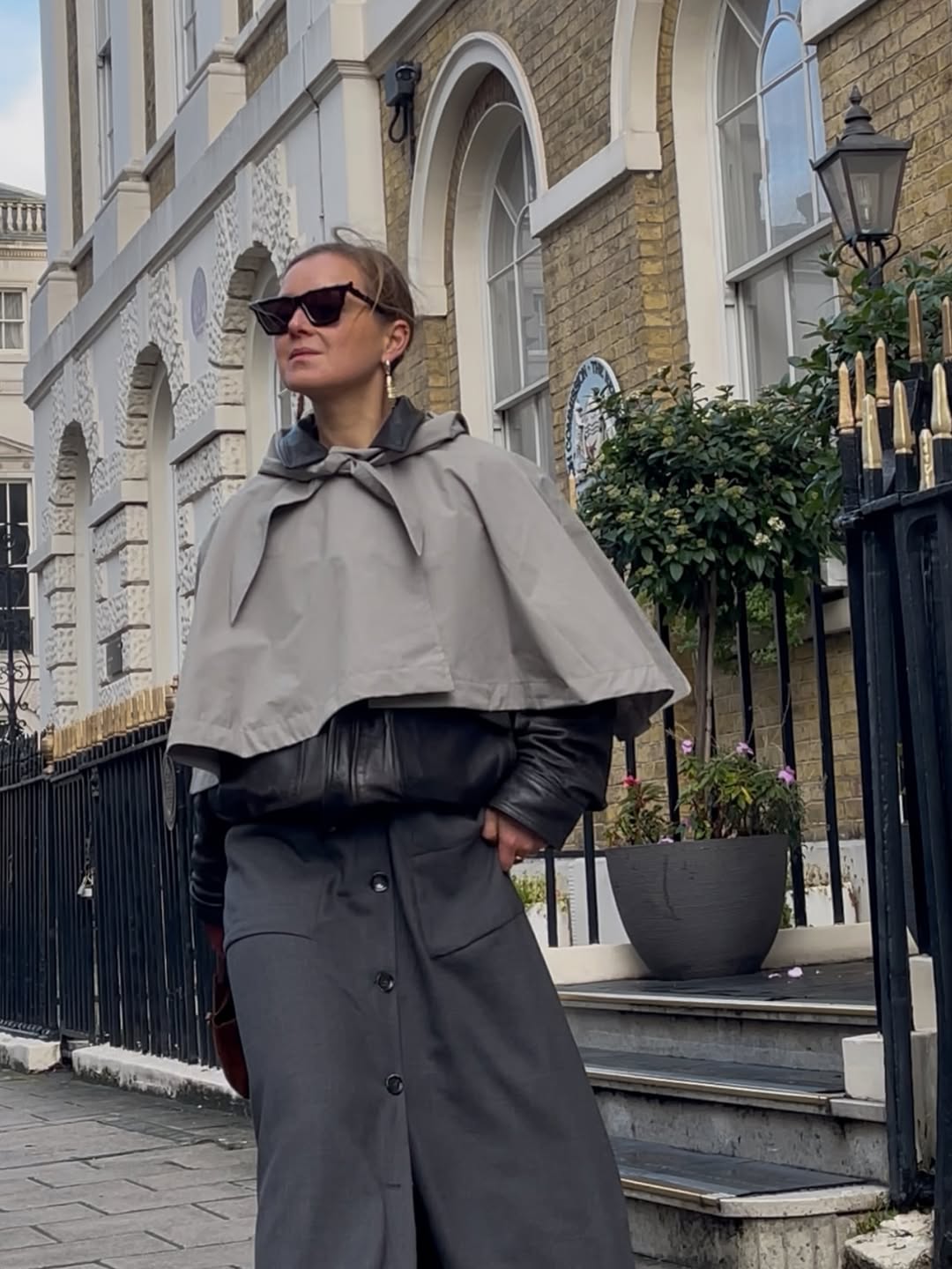 Influencer Anna Borisovna wearing a cape coat.