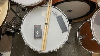 Vibes Hi Fidelity Earplugs on a snare drum with a pair of drumsticks