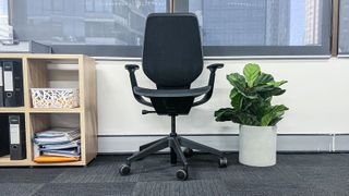 Steelcase Karman beside a shelving unit and potted plant
