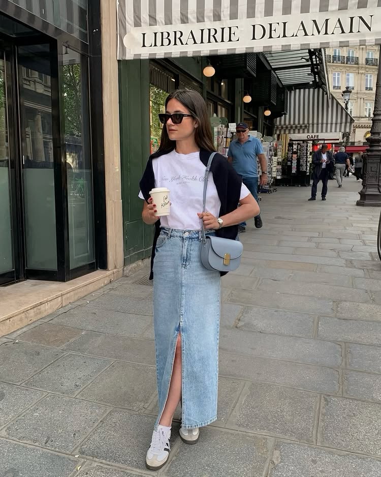@leasy_inparis in a denim skirt with coach shoes, a white T-shirt and navy jumper knot