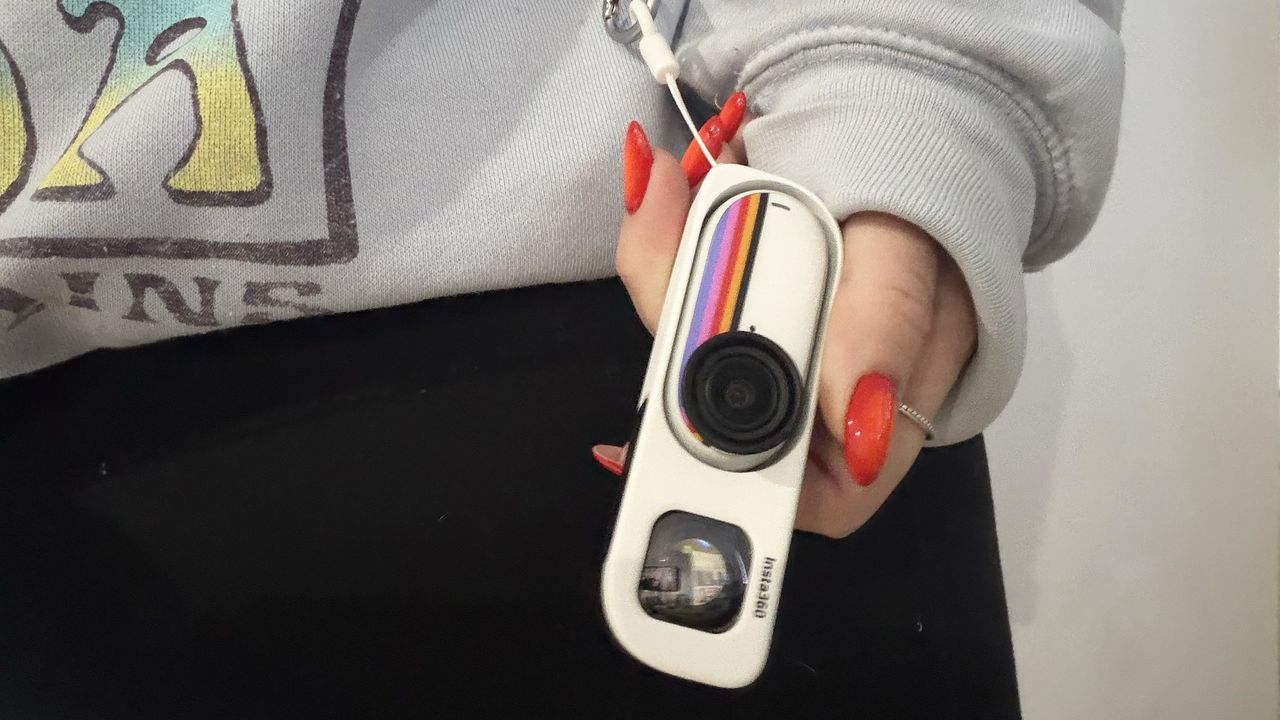 Hand holding Insat360 camera while wearing the waist viewfinder