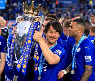 Shinji Okazaki, wearing his winner's medal, celebrates with the Premier League trophy after winning the 2015/16 title with Leicester City